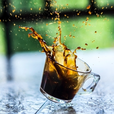 Photo of a coffee cup that has been dropped and has spilling