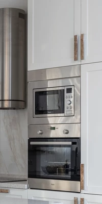 A photo of a built-in microwave in a modern light coloured kitchen