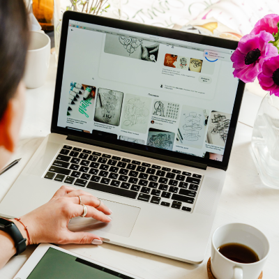Photo of a girl sitting at laptop with flowers on the desk