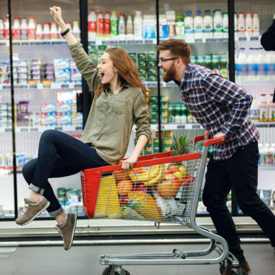 Man pushing a lady in a shopping cart
