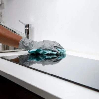 Person cleaning a modern kitchen worktop