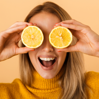 Photo of a lady holding lemons over her eyes