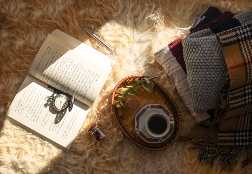 Book and coffee on a rug outside