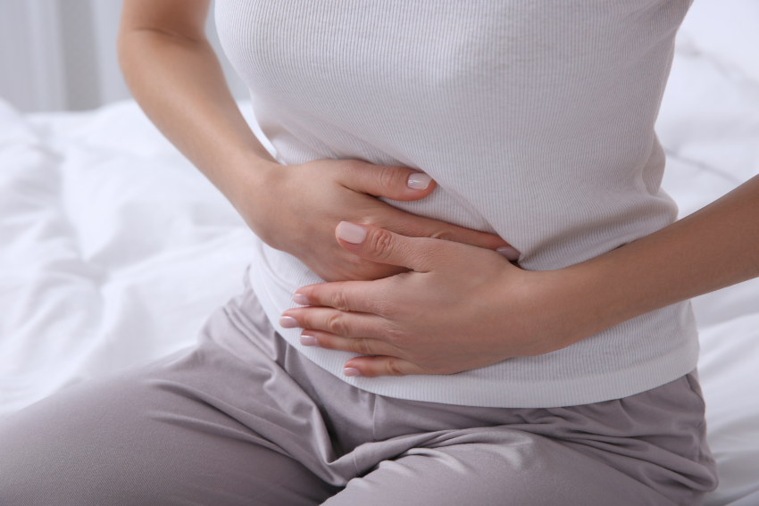 Girl sat on bed feeling sick