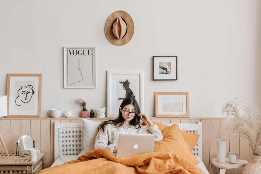 Girl sat on bed with laptop