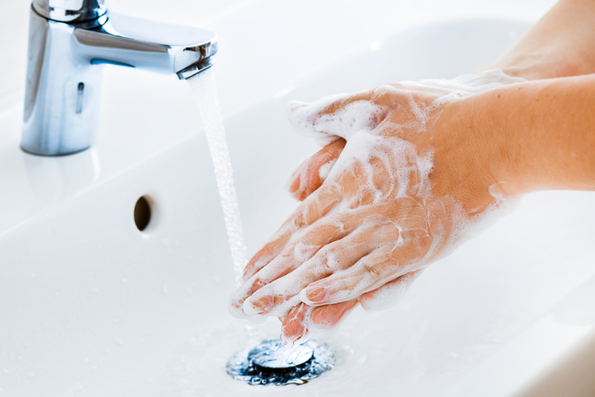 Washing hands in a white ceramic sink