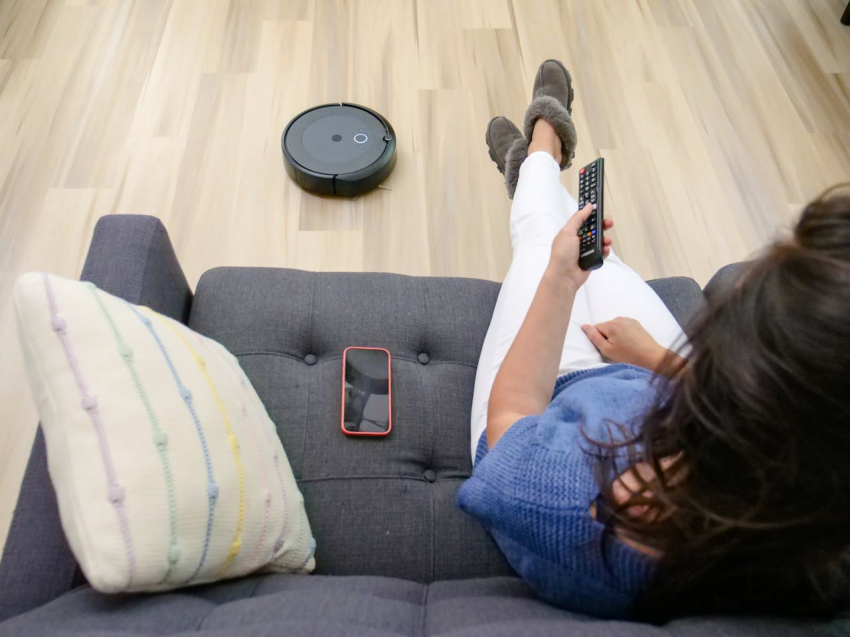Lady sat on sofa with robot vacuum
