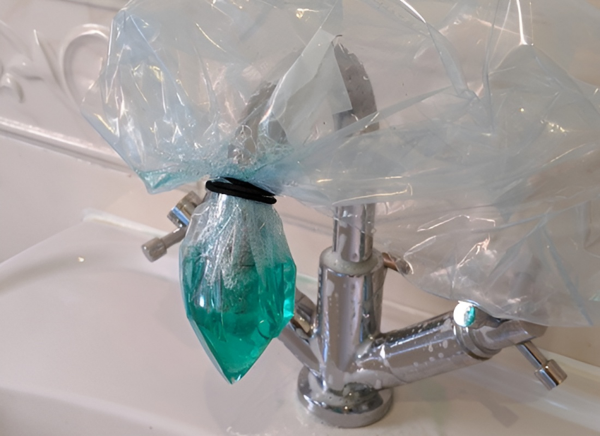 Bag over the end of a tap containing limescale remover